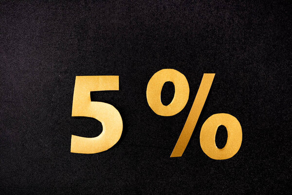 верхний вид золотых 5 процентов знаков на черном фоне
