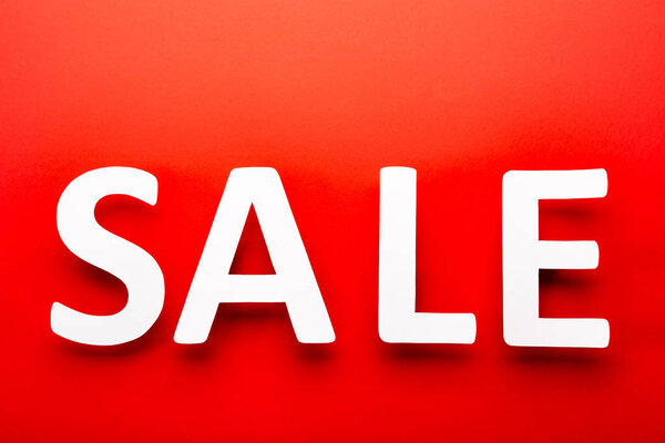 top view of price tag with sale lettering isolated on red