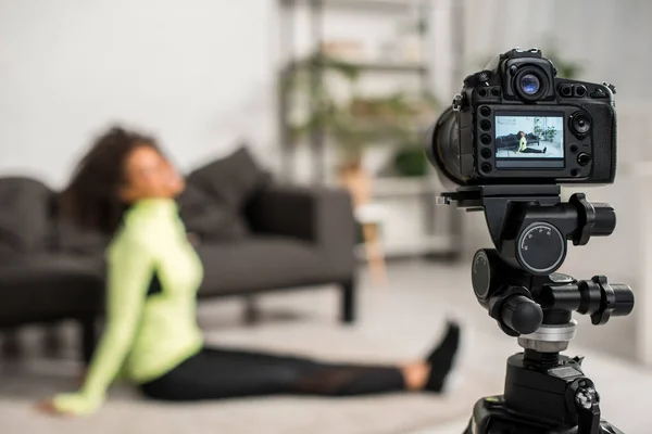 带着疲惫的非洲裔美国视频博客的数码相机有选择地聚焦在地毯上展示 — 图库照片