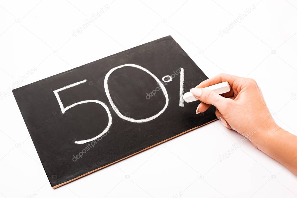 cropped view of woman holding chalk near number 50 and percent sign written on chalkboard isolated on white