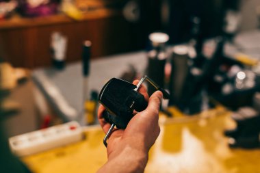 cropped view of worker holding grip vice in repair shop 