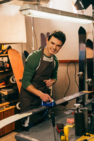 Smiling Worker Waxing Ski Wax Iron Repair Shop — Stock Photo, Image