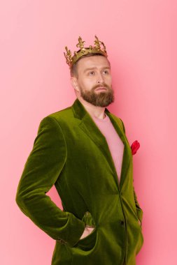 handsome man with crown in velour jacket looking away on pink background  clipart