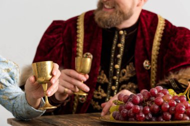 selective focus of grape and queen with king on background isolated on grey