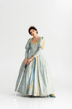 attractive queen with crown holding sword on grey background 