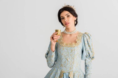attractive queen with crown holding cup isolated on grey