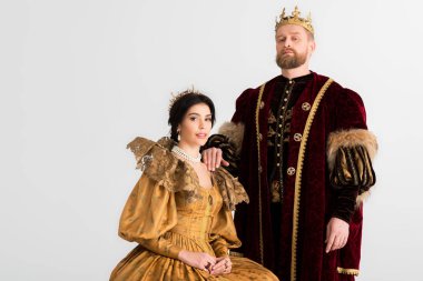 queen and king with crowns looking at camera isolated on grey 