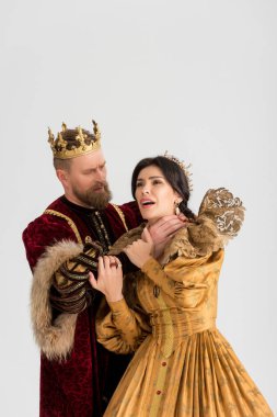 king with crown choking attractive queen isolated on grey