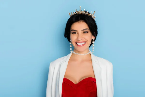 Mujer Sonriente Con Corona Mirando Cámara Sobre Fondo Azul —  Fotos de Stock