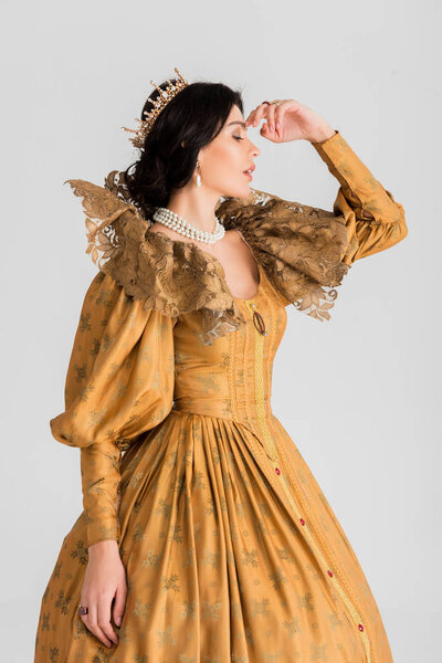 side view of tired queen with crown isolated on grey