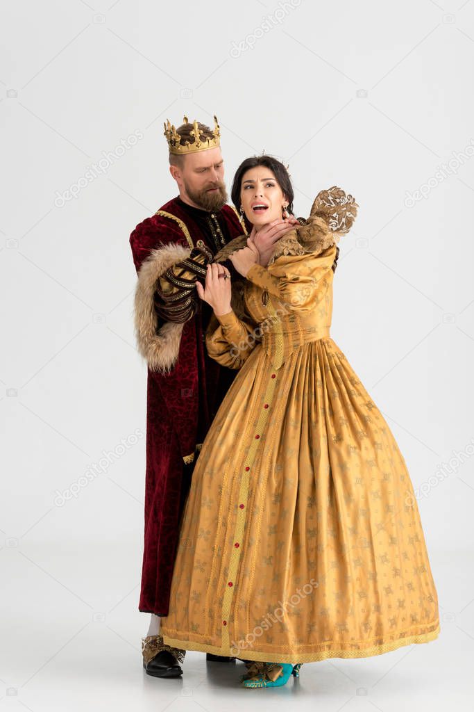 king with crown choking attractive queen on grey background 