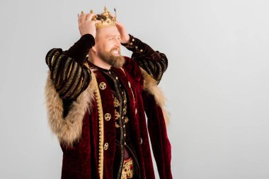 smiling king wearing crown on head isolated on grey