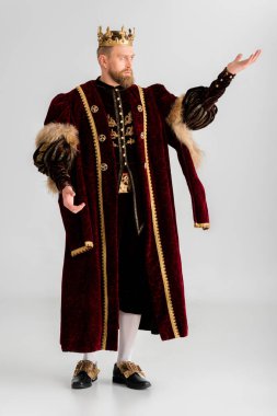 king with crown pointing with hand on grey background 