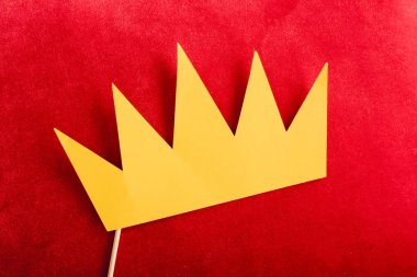 top view of paper crown on red pillow 