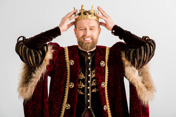 smiling king wearing crown on head isolated on grey