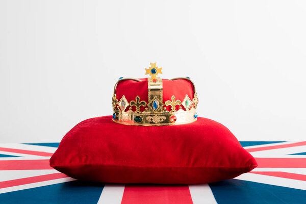 golden crown on pillow and british flag isolated on white