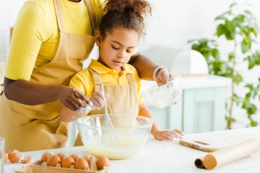 Afro-amerikan bir annenin tatlı bir kızın yanında kaseyi tutuşu. 