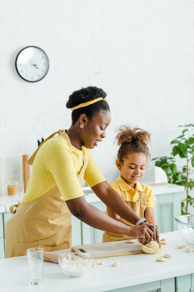 明るいアフリカ系アメリカ人の母親と幸せな子供がキッチンで生餃子を彫る — ストック写真
