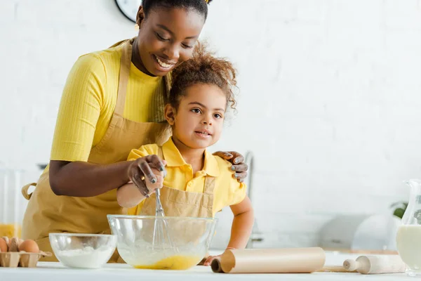 Cute African American Kid Cheerful Mother Holding Whisk Bowl While — Stock Photo, Image