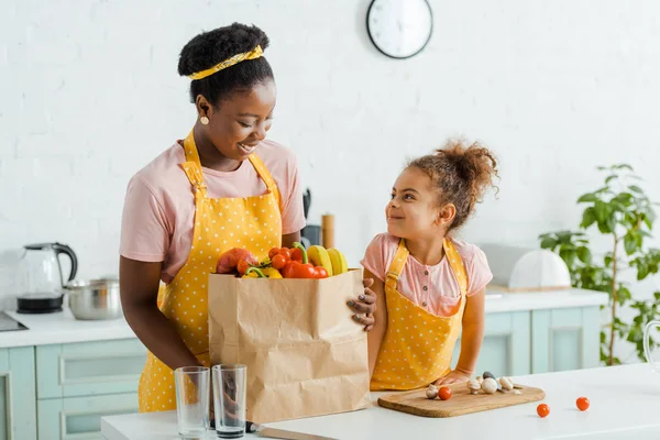 Criança Americana Africana Feliz Olhando Para Mãe Perto Mantimentos — Fotografia de Stock