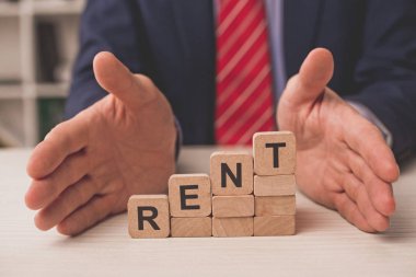 Kiralık harflerle ahşap küplerin yanına ellerini koyan ajanın kırpılmış görüntüsü. 