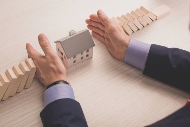 Emlakçı, ahşap küplerle karton ev modelleri arasında el ele veriyor. 