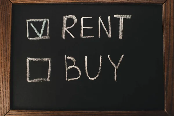 top view of chalkboard with rent and buy lettering