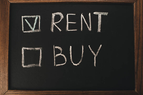 top view of chalkboard with rent and buy lettering 