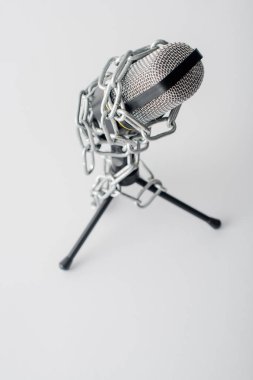 Metalik zincirlerdeki mikrofonun seçici odak noktası beyaza izole edilmiş, konuşma özgürlüğü kavramı 