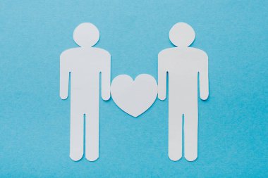 top view of paper cut figures of homosexual couple isolated on blue, human rights concept  clipart