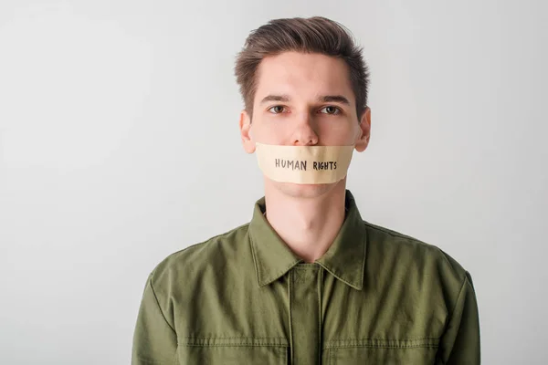 man with scotch tape on mouth with human rights lettering isolated on white