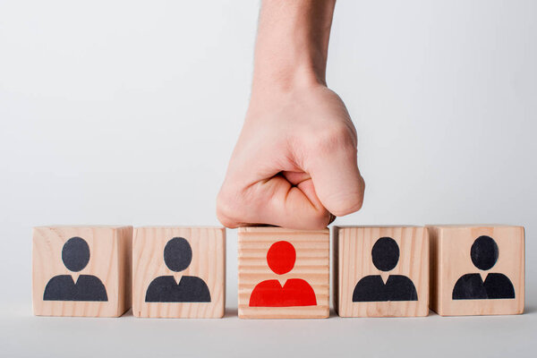 обрезанный взгляд человека с сжатым кулаком рядом с деревянными кубиками, изолированными на белом, концепция прав человека
 