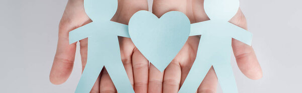 панорамный снимок женщины, держащей в руках фигуры людей, вырезанных из бумаги с сердцем, концепция прав человека
 