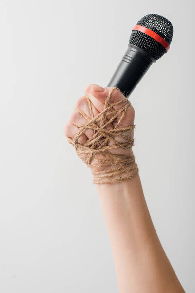 cropped view of woman with rope on hand holding microphone isolated on white, freedom of speech concept 