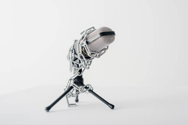 microphone in metallic chains isolated on white, freedom of speech concept 