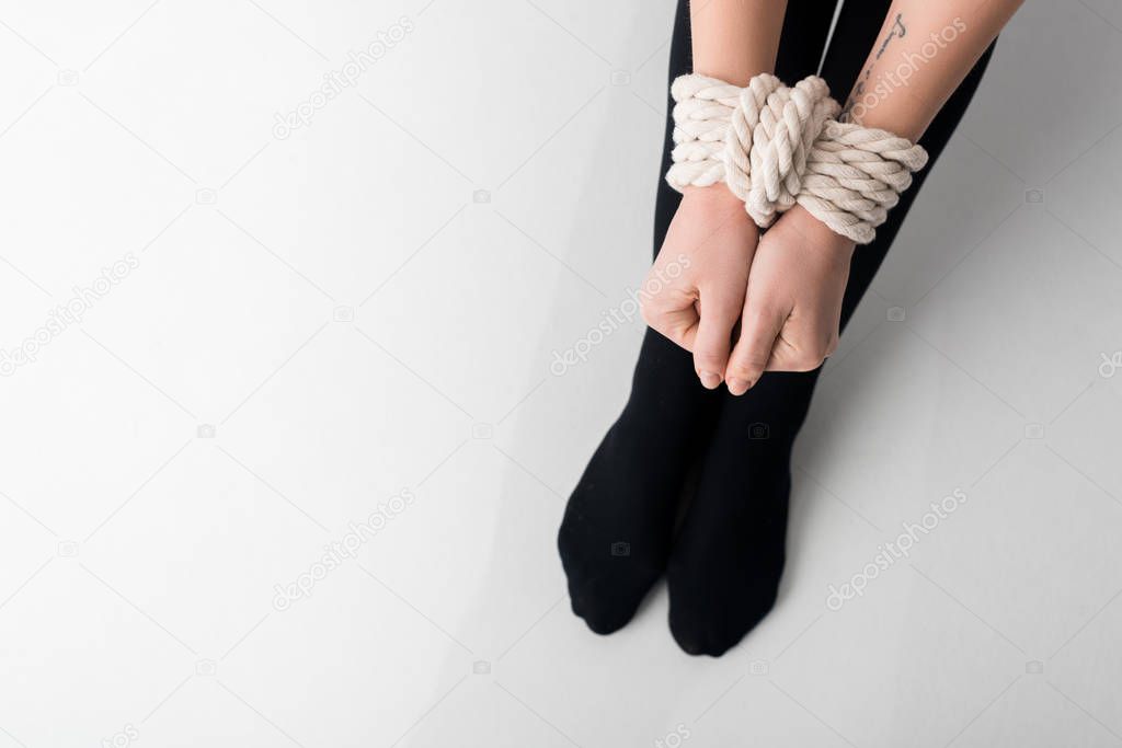 top view of victim with tied hands on white, human rights concept 