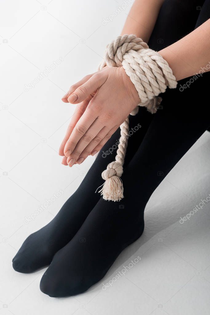 cropped view of victim with tied hands on white, human rights concept 