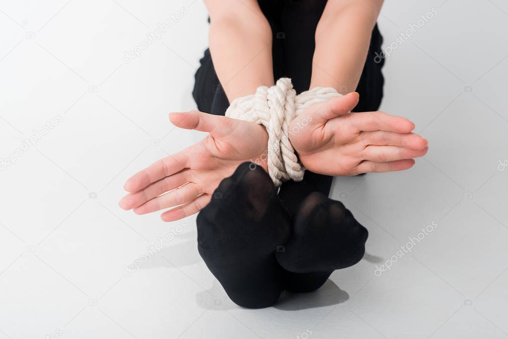 cropped view of woman with tied hands on white, human rights concept 