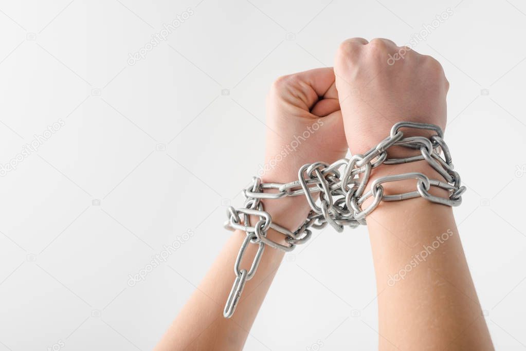 cropped view of woman in metallic chains isolated on white, human rights concept 