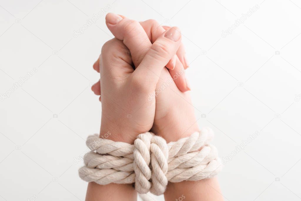 cropped view of woman with rope on praying hands isolated on white, human rights concept 