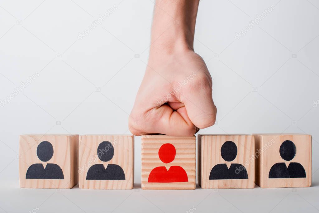 cropped view of man with clenched fist near wooden cubes isolated on white, human rights concept 