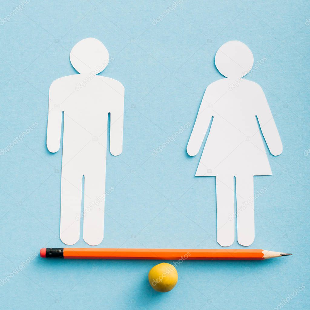 paper cut figures of couple as gender equality on pencil with small ball isolated on blue, sexual equality concept 