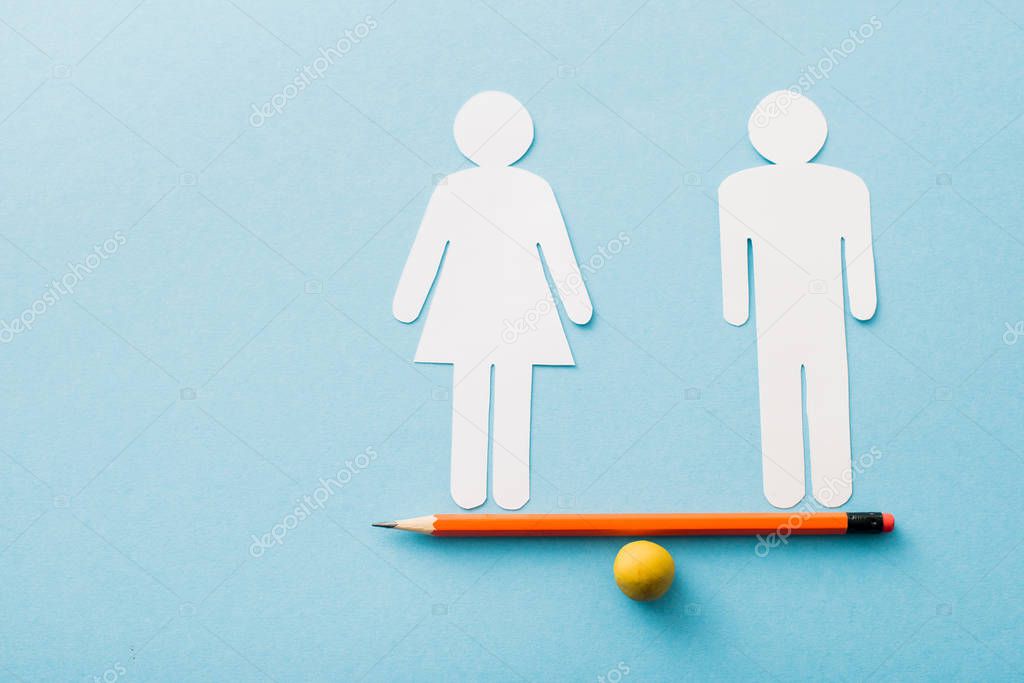 small ball and pencil with paper cut of couple isolated on blue, sexual equality concept 