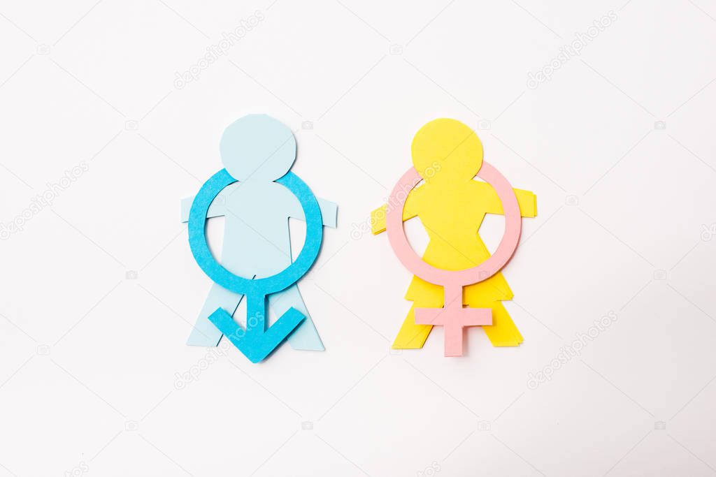 top view of colorful paper cut people near gender signs isolated on white, sexual equality concept 