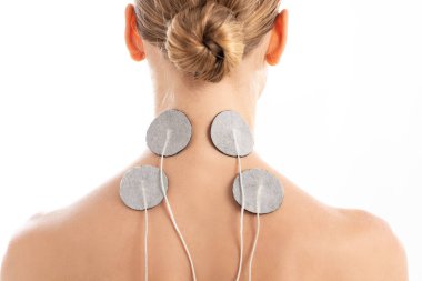 Back view of young woman with electro stimulation electrodes on neck isolated on white clipart