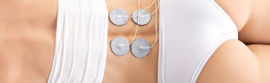 Top view of electrodes on back of woman during electrode treatment, panoramic shot clipart
