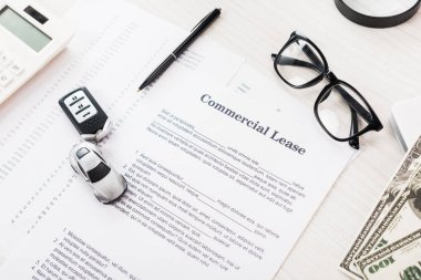 top view of document with commercial lease lettering near toy car, pen, money and glasses clipart