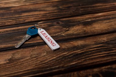  key with leasing lettering on wooden surface 