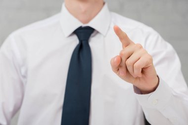 cropped view of realtor in suit pointing with finger on white, leasing concept 
