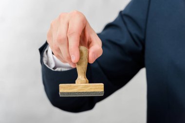 cropped view of realtor holding stamp isolated on white 